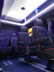 rozświetlone wnętrze busa z ciemnymi fotelami